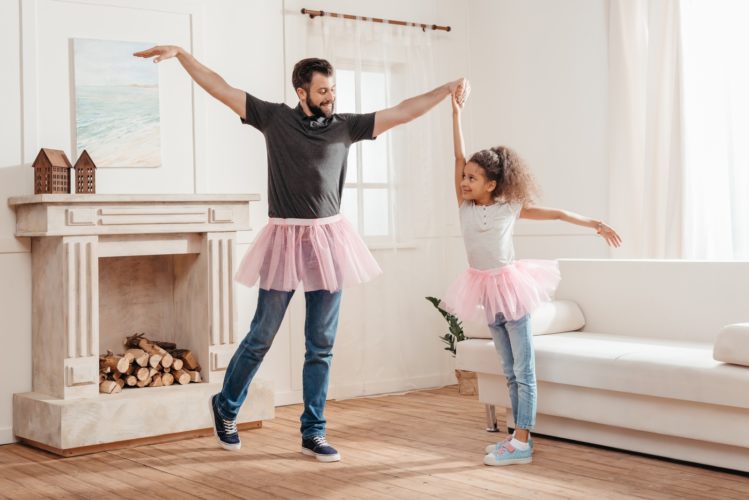 padre e figlia fanno ginnastica in casa ballando