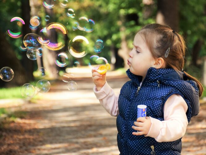 Arriva l'estate: ecco 5 idee divertenti per far giocare i nostri bambini all'aria aperta Bambina fa le bolle di sapone